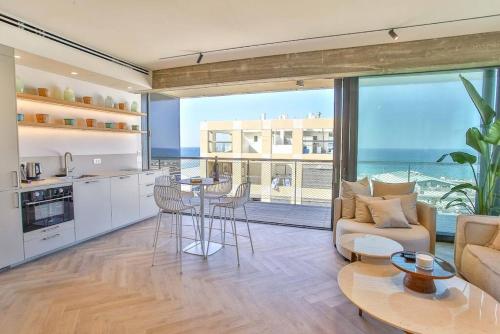 a kitchen and living room with a view of the ocean at High End 1BD Beach Apartment in Tel Aviv