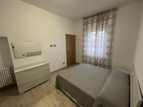 1 dormitorio con 1 cama, vestidor y ventana en Era apartments 2 posizione Milano-Bergamo-Monza, en Caponago