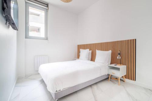 een witte slaapkamer met een groot bed en een raam bij Cosy flat for 6 people #2 in Asnières-sur-Seine