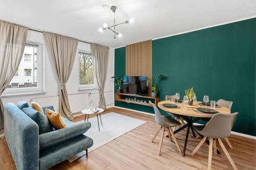 a living room with a table and a blue couch at Stadt-Apartment 3 Zimmer mit Terasse in Hannover