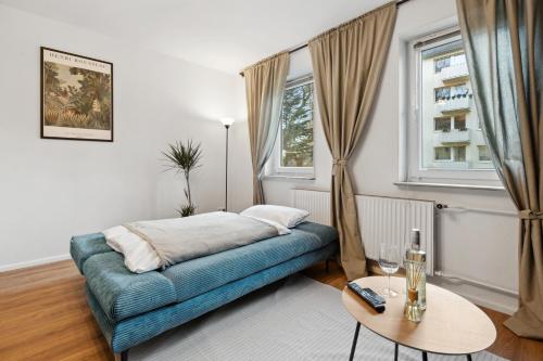 a living room with a blue couch and a table at Stadt-Apartment 3 Zimmer mit Terasse in Hannover