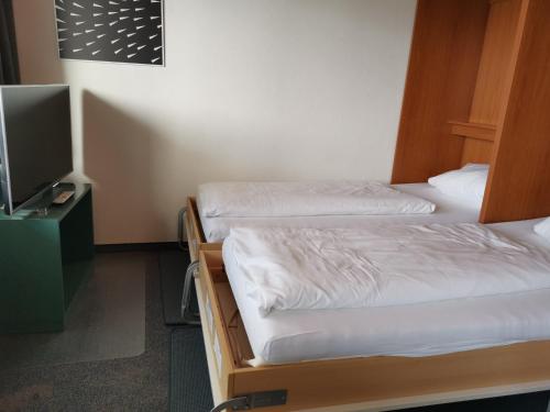 Habitación con 2 camas individuales y TV. en Nordseeblick Nordseeblick 011, en Norderney