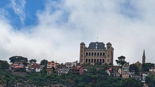 a large building on top of a hill with houses at Le Manoir in Antananarivo