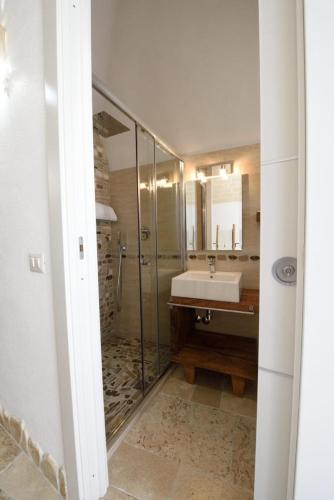 a bathroom with a glass shower and a sink at La casa del geko in Vieste