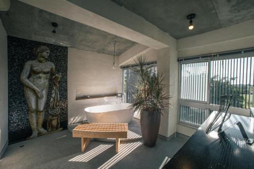 a bathroom with a large statue and a bath tub at 57villa in Hengchun South Gate