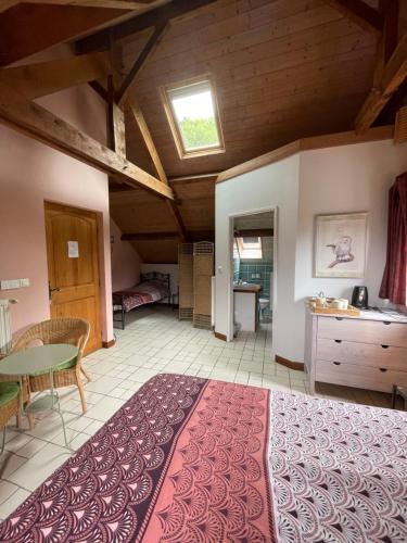 um quarto grande com uma cama grande e uma mesa em chambres d'hôtes las Vignes em Beaucens