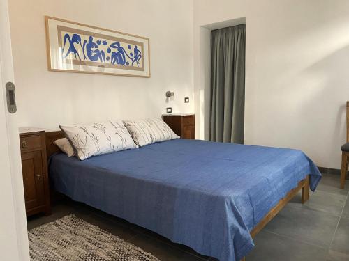 una camera da letto con un letto con un piumone blu di Gateway to Sinis a Baratili San Pietro
