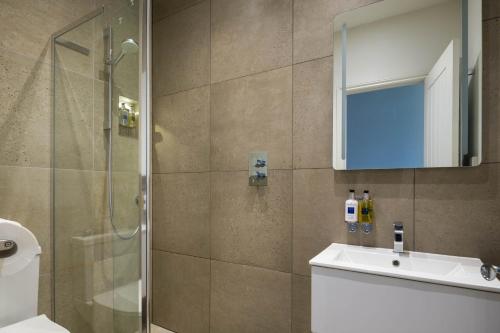 a bathroom with a shower and a sink and a mirror at Housel Bay Hotel in Lizard