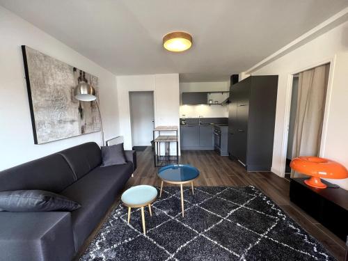 a living room with a couch and a kitchen at Sublime T2 avec balcon in Montauban