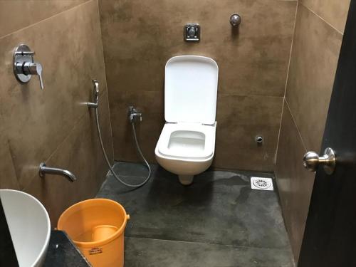 a bathroom with a white toilet in a stall at New Mango Dormitory in Mumbai