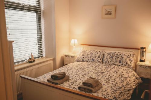 Hidden Oasis in the heart of Kingsbridge في كينغسبريدج: غرفة نوم عليها سرير وفوط