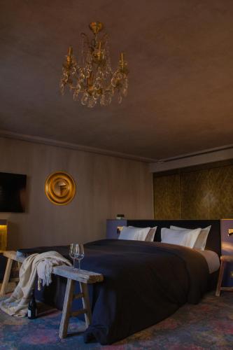 a bedroom with a large bed and a chandelier at Unique Boutique Hotel Antibes Juan-les-Pins in Antibes
