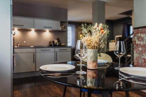 a table with two wine glasses and a vase with flowers at The Circus Hotel in Berlin