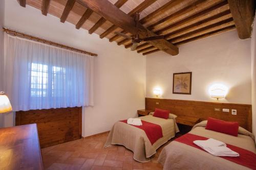 two beds in a room with wooden ceilings at Tenuta Decimo - Il Borgo Di Mariano in San Gimignano