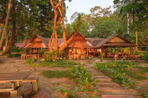 ein Restaurant mit Tischen und Stühlen in einem Wald in der Unterkunft JOY Bungalow Resort and Restaurant in Ko Jum