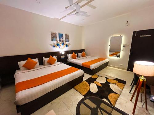 a hotel room with two beds and a mirror at The कस्तूरी in Maihar