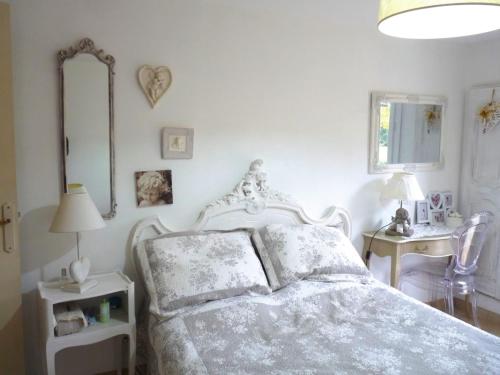 ein weißes Schlafzimmer mit einem Bett und einem Spiegel in der Unterkunft SALSA in Ceyreste