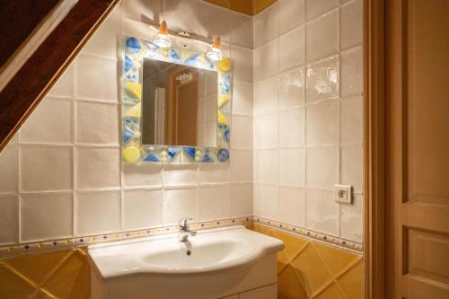 W łazience znajduje się umywalka i lustro. w obiekcie Villa en pierre 4 pers avec Piscine w mieście Coly