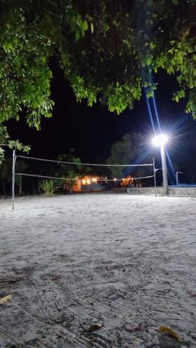 ein Volleyballplatz in der Nacht mit Licht in der Unterkunft Chácara Refúgio de Assis in Pirambu
