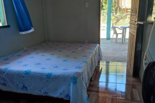 Schlafzimmer mit einem Bett mit blauer Decke in der Unterkunft Chácara Refúgio de Assis in Pirambu
