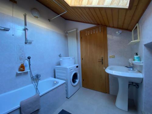 a bathroom with a washing machine and a sink at Casetta Turati in Castelfondo