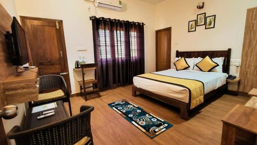 a bedroom with a bed and a television in a room at Hill Crest Resort - Coorg in Madikeri