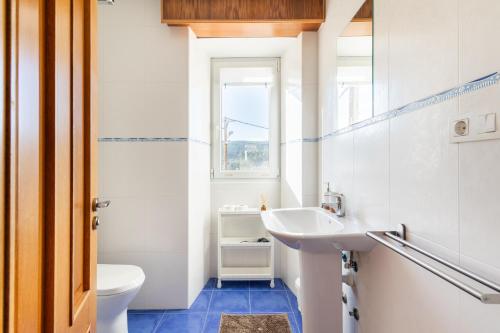 a bathroom with a sink and a toilet and a window at A casa de Valenza 