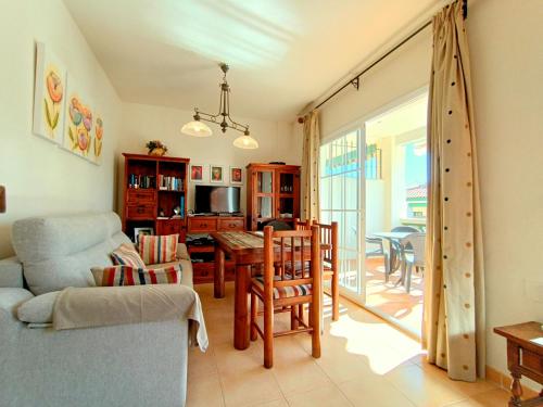 a living room with a table and chairs and a dining room at Apartamentos StarNerja II in Nerja