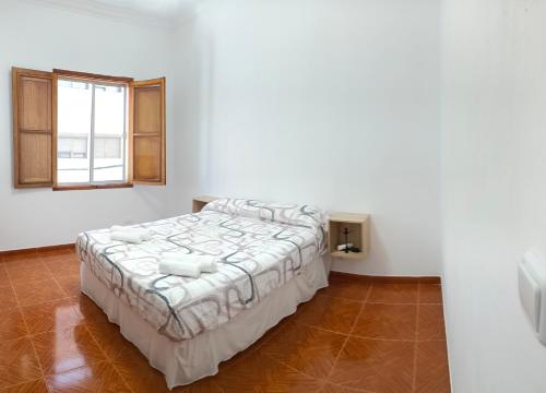Un dormitorio con una cama en una habitación blanca. en CLARET LAS PALMAS DE GRAN CANARIA CITY, en Las Palmas de Gran Canaria