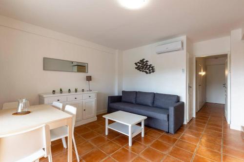 uma sala de estar com um sofá azul e uma mesa em La Ciotat Appartement T2 piscine clim parking em La Ciotat