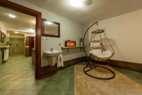 a bathroom with a swing chair and a sink at Hotel Liptov Holiday *** in Liptovský Mikuláš