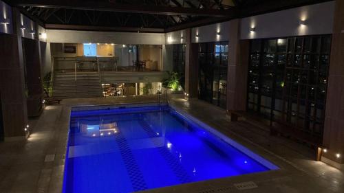 a large swimming pool with blue water in a building at Flat espaçoso e confortável no Piazza Navona in Porto Alegre