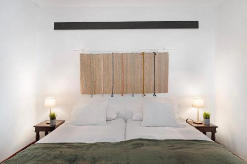 een slaapkamer met een groot bed met twee nachtkastjes bij Finca Emblemática - Nº2 Chibusque in La Vegueta