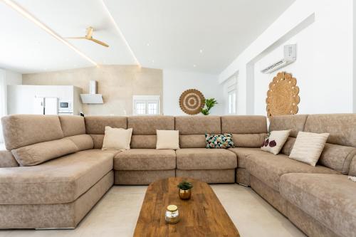 a living room with a brown couch and a coffee table at MalagaSuite Villa Nomada El Torcal in Antequera