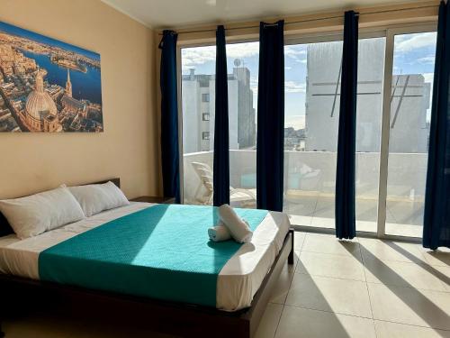 a bedroom with a bed and a large window at Malta Paradise Central Accomodation in St Julian's