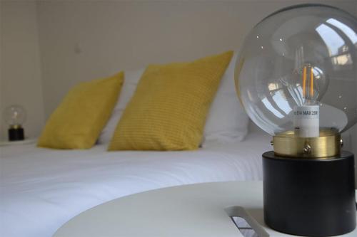 une chambre avec un lit avec une lampe en verre sur une table dans l'établissement La Garde de la Tonnellerie, à Chartres