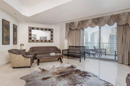a living room with a couch and a table at Trident Grand Residence,Dubai Marina - 3BR Apartment - Allsopp&Allsopp in Dubai