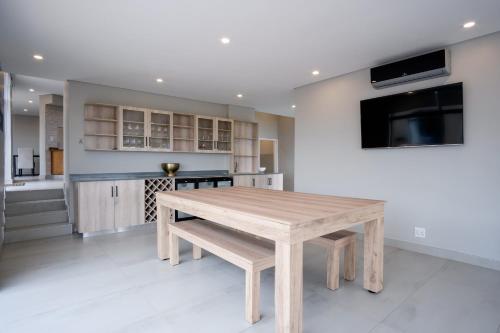 a wooden table in a room with a kitchen at 145 Forest Drive - Umhlanga in Durban
