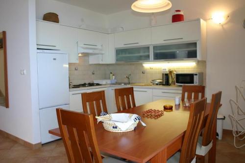 a kitchen with a wooden table and white cabinets at Apartments Boris in Omiš