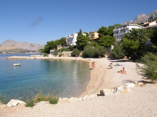 a group of people on a beach near the water at Apartments Boris in Omiš