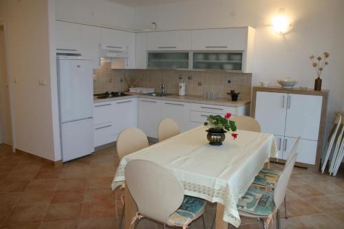 a kitchen with a table and chairs and a kitchen with white cabinets at Apartments Boris in Omiš