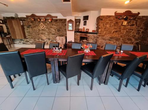 uma sala de jantar com uma mesa de madeira e cadeiras pretas em Casa de vacanta La Locanda Dubova em Dubova
