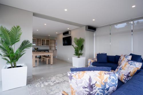 a living room with a blue couch and a table at 145 Forest Drive - Umhlanga in Durban