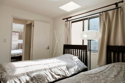 a bedroom with two beds and a window at 100㎡ Cozy Villa in Shinjuku｜JR Shin-Ōkubo Sta. 7mins. in Tokyo