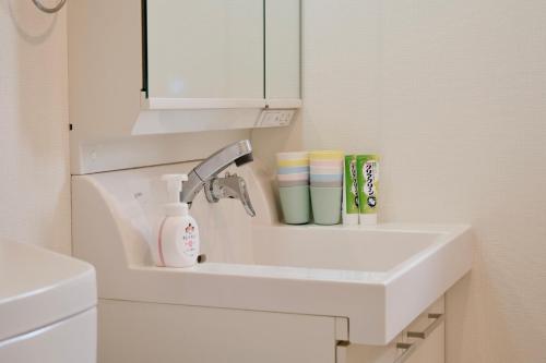 a white sink in a bathroom with a mirror at 100㎡ Cozy Villa in Shinjuku｜JR Shin-Ōkubo Sta. 7mins. in Tokyo