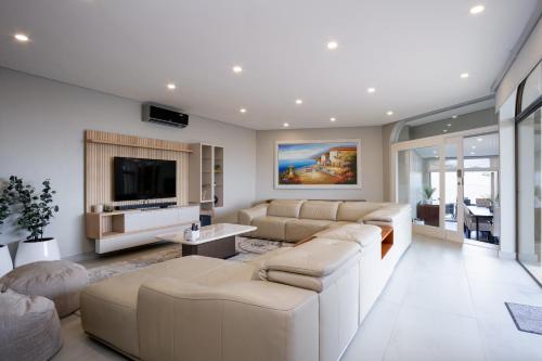 a living room with two couches and a tv at 145 Forest Drive - Umhlanga in Durban