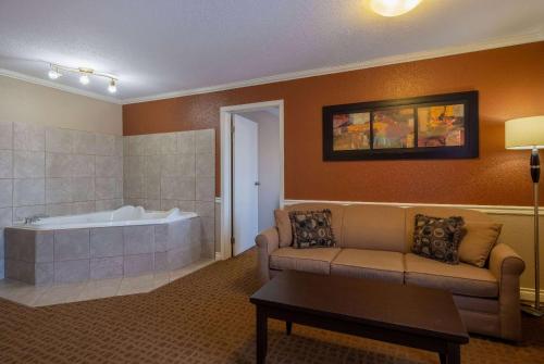 ein Wohnzimmer mit einem Sofa und einer Badewanne in der Unterkunft Super 8 by Wyndham Edmonton International Airport in Leduc