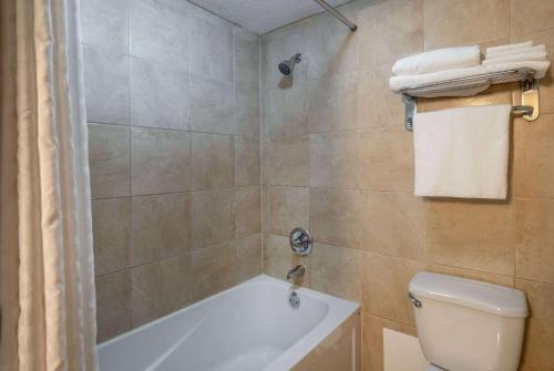 a bathroom with a white tub and a toilet at Super 8 by Wyndham Edmonton International Airport in Leduc