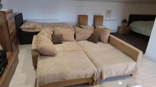 Sofá marrón en la sala de estar con cama en Leipzig-Neuseeland-Ferienwohnung, en Rötha
