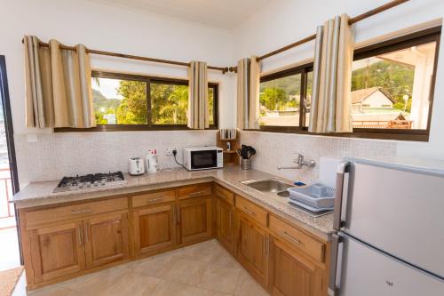 eine Küche mit Spüle und Kühlschrank in der Unterkunft Beach Cottages in Bel Ombre